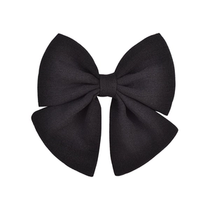 Détail d'un grand nœud papillon noir en mousseline avec tissu texturé sur fond blanc