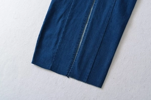Detail eines dunkelblauen Jeanskleides mit Ziernähten und rohem Fransen-Saum
