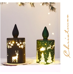 Close-up of LED Christmas candles with Santa and deer patterns on a snowy background