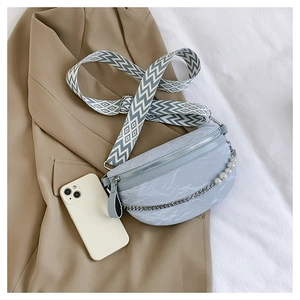 Detail of light blue marble pattern crescent bag with pearl chain and woven strap