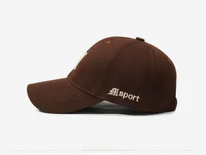 Detail shot of sport embroidery on side of dark brown cotton canvas baseball cap