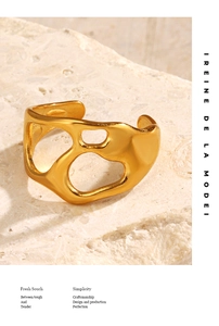 Detail of 18K gold-plated irregular cutout ring on a textured natural stone background