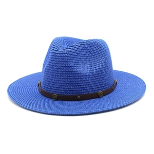 Close-up of blue straw fedora hat featuring a brown leather band and vintage metal rivets
