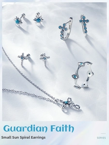 Detail of S925 sterling silver cross necklace and sun stud earrings with blue gemstones