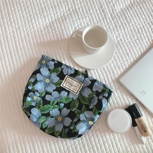 Floral jacquard pouch detail with beige label and premium vintage flower embroidery