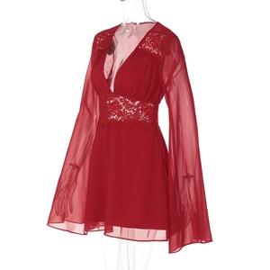 Détail de la robe rouge à décolleté en V profond avec dentelle et manches évasées en tulle