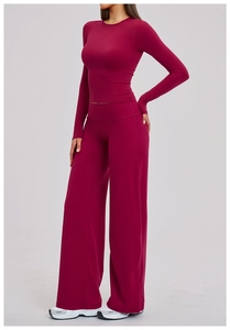 Detail of high-waist wide-leg yoga pants and tight long-sleeve top in deep rose red