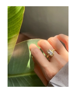 Macro shot of gold hammered texture ring featuring a rectangular clear gemstone on hand