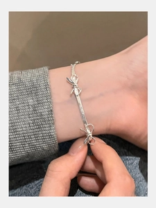 Close-up of a silver bow snake chain bracelet on a wrist for daily fashion style