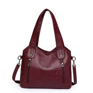 Red lychee grain leather tote bag with sturdy handles and adjustable shoulder strap