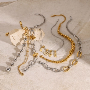 Macro shot of stainless steel chain bracelets and LOVE pendant with crystal heart charm