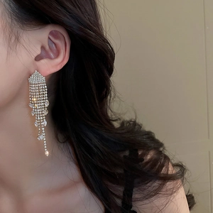 Detail of silver long tassel earrings with sparkling rhinestones worn by a female model