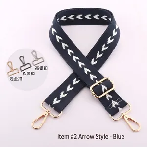 Detailed view of adjustable navy blue bag strap with white arrow pattern and hardware options