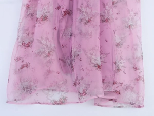 Detail of pink floral organza fabric featuring vintage angel prints and sheer texture