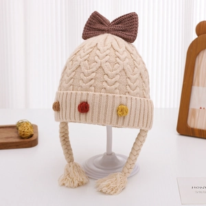 Dettaglio del cappello invernale in maglia per neonati con fiocco e pompon
