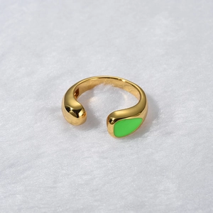 Macro shot of gold adjustable ring featuring a translucent green teardrop charm
