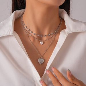 Detailed view of triple-layered silver locket necklace with vintage heart pendant and pearls