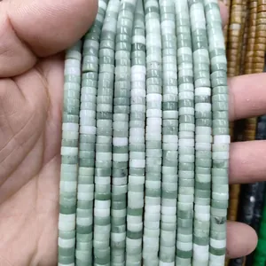 Macro close-up of natural green and white stone rondelle beads for DIY jewelry making