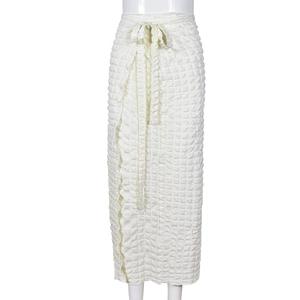 Close-up of cream high-waisted wrap skirt showing quilted bubble texture and waist tie detail