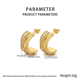 Détail des boucles d'oreilles en C en acier inoxydable doré avec des strass brillants