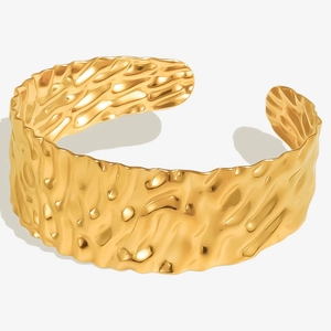 Detail of 18k gold plated stainless steel cuff bracelet with hammered water wave texture