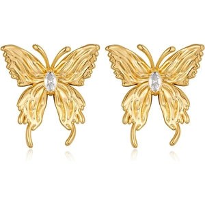 Detail shot of golden bow earrings with sparkling crystal center on a clean white backdrop