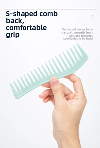 Detail of light green wide-tooth hair comb with ergonomic S-shaped handle design