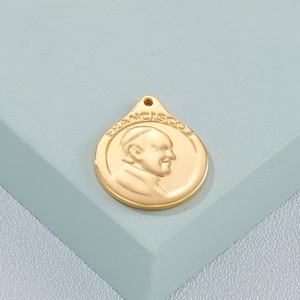 Macro detail of a golden stainless steel pendant with relief portrait of Pope Francisco