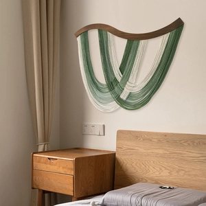 Décoration murale bohème avec glands de coton arqués verts et crème sur barre de bois