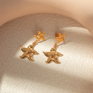 Golden starfish drop earrings in nautical metal design for beach fashion style