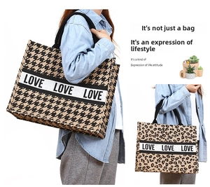 Detailed view of large jute tote bags in leopard and houndstooth prints with Love ribbon