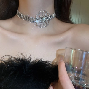 Nahaufnahme einer funkelnden Strass-Blumenkette in Silber-Finish an einem Modelhals