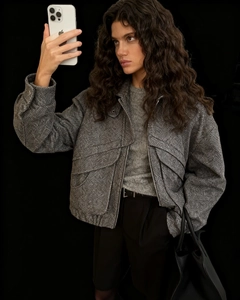Close-up of grey herringbone texture jacket with drop shoulder and large flap pocket