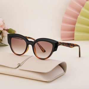 Fashion cat eye sunglasses with black frame and tortoiseshell temples including beige case