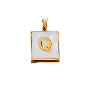 Macro view of square gold pendant featuring a mother of pearl inlay and letter Q detail