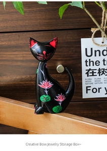 Detail view of black wooden cat storage box with hand-painted pink lotus flower designs