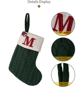 Detail view of green knitted Christmas stocking with letter M embroidery and lanyard