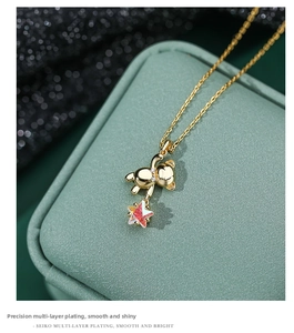 Detail of s925 silver golden bear necklace with iridescent star pendant on jewelry box
