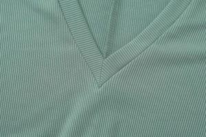 Close-up of V-neckline and ribbed knit texture on bean green slim fit bodysuit