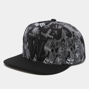 Close-up of the 3D embroidered letter W on a black snapback hat with street style patterns