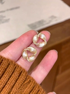 Detailed close-up of 14K gold plated spiral flower earrings with crystal accents and pearls