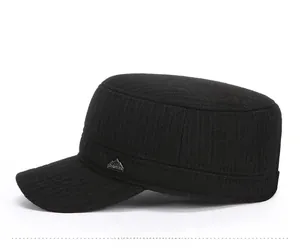 Side view of black military flat top cap with textured fabric and metal peak logo