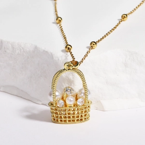 Vue détaillée du pendentif panier de fleurs doré avec perles et zircons sur pierre blanche