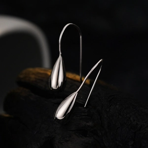 Minimalist S925 sterling silver water drop earrings with polished finish on dark wood