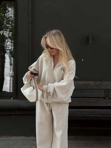 Detail of beige half-zip sweatshirt and matching joggers for women in casual outdoor scene