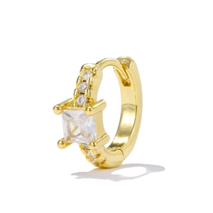 Macro detail of gold huggie earring featuring a square zircon and micro-paved stones