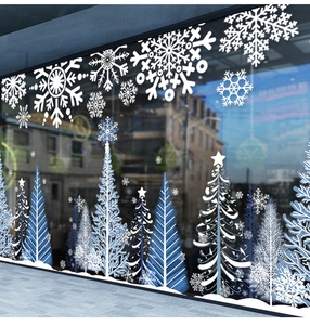 Dettaglio di adesivi per finestre con fiocchi di neve bianchi e blu e alberi di Natale