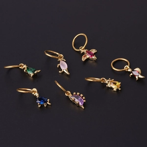 Golden dinosaur earrings set with colorful zircon stones on a dark background