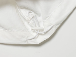Vue détaillée du pantalon en nylon blanc avec cordon de serrage réglable et arrêt