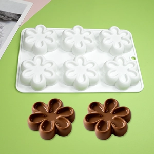 Detailed view of white 6-cavity flower silicone mold with finished chocolate pieces